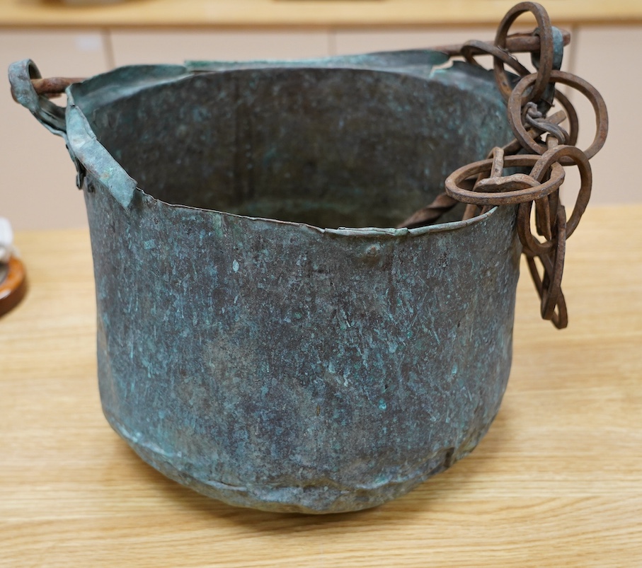 A 17th / 18th century copper cooking pot, 29cm to top of handle. Condition - poor